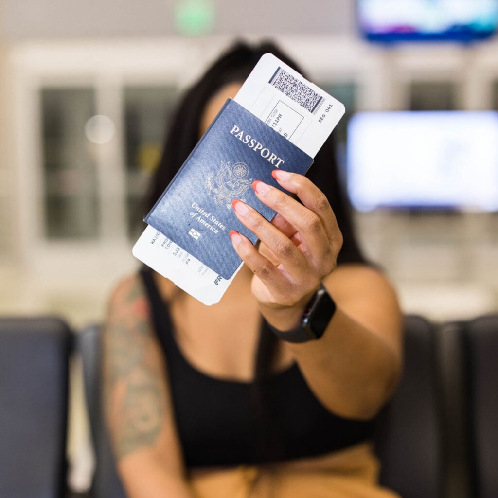 A woman holding a passport up in front of her face for how to use the mobile passport app